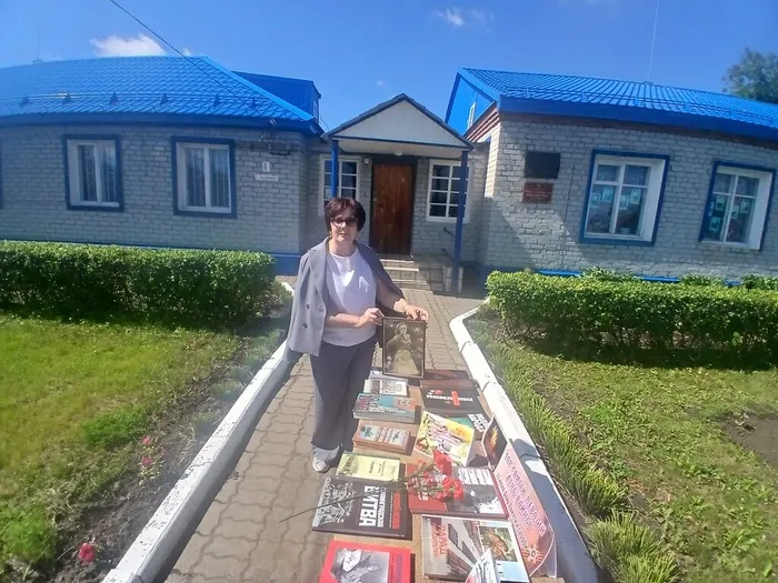 Заведующая отделом обслуживания О.Г.Морозова у книжной выставки